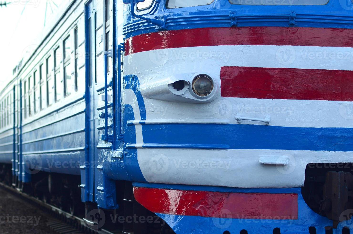Old soviet electric train with outdated design moving by rail photo