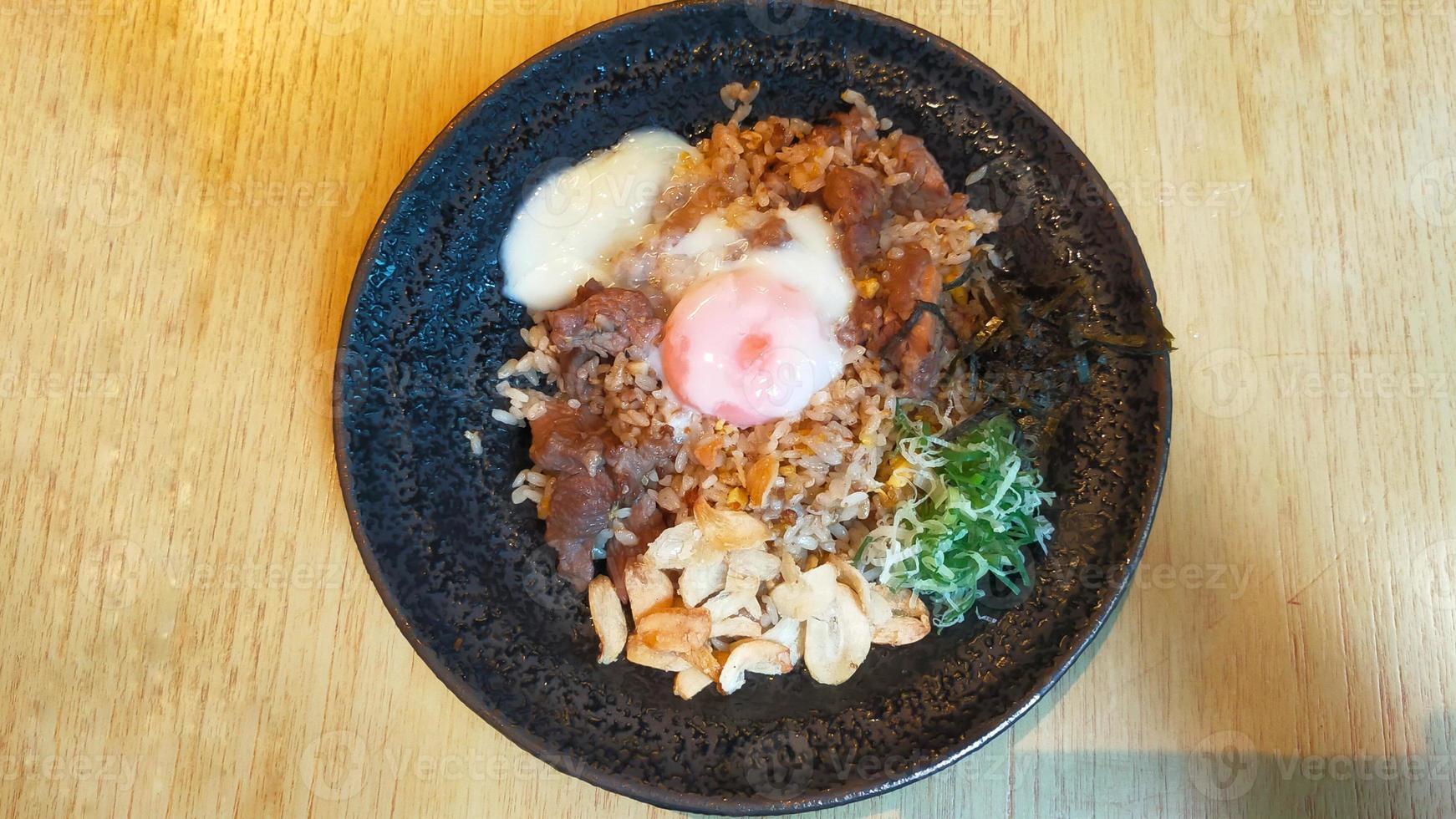 un menú de un restaurante de sushi arroz frito con ajo y ternera con huevo onsen es arroz frito con cebolla con ternera a medio cocer y huevo, muy sabroso. foto