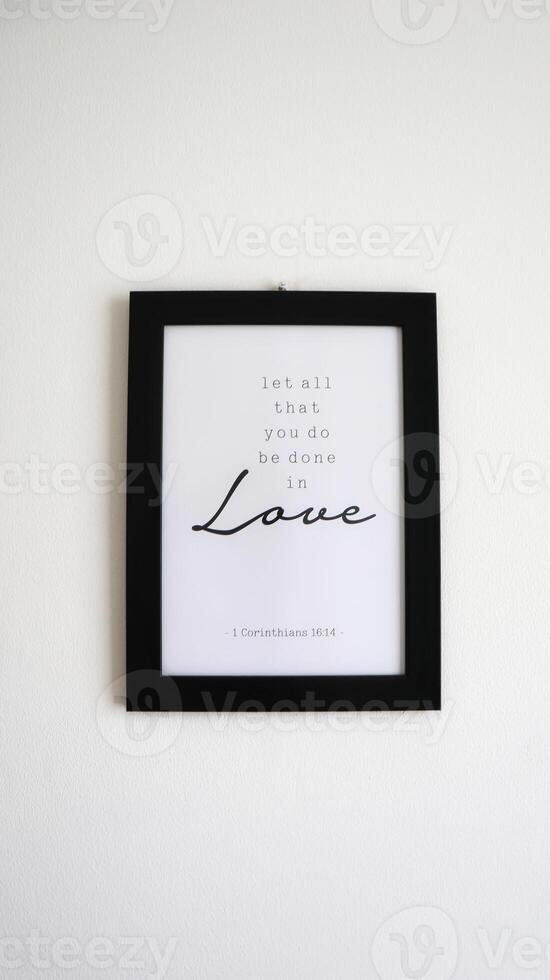 A photo of a frame that reads a bible verse in 1 Corinthians 16.14 about let all that you be done in love.