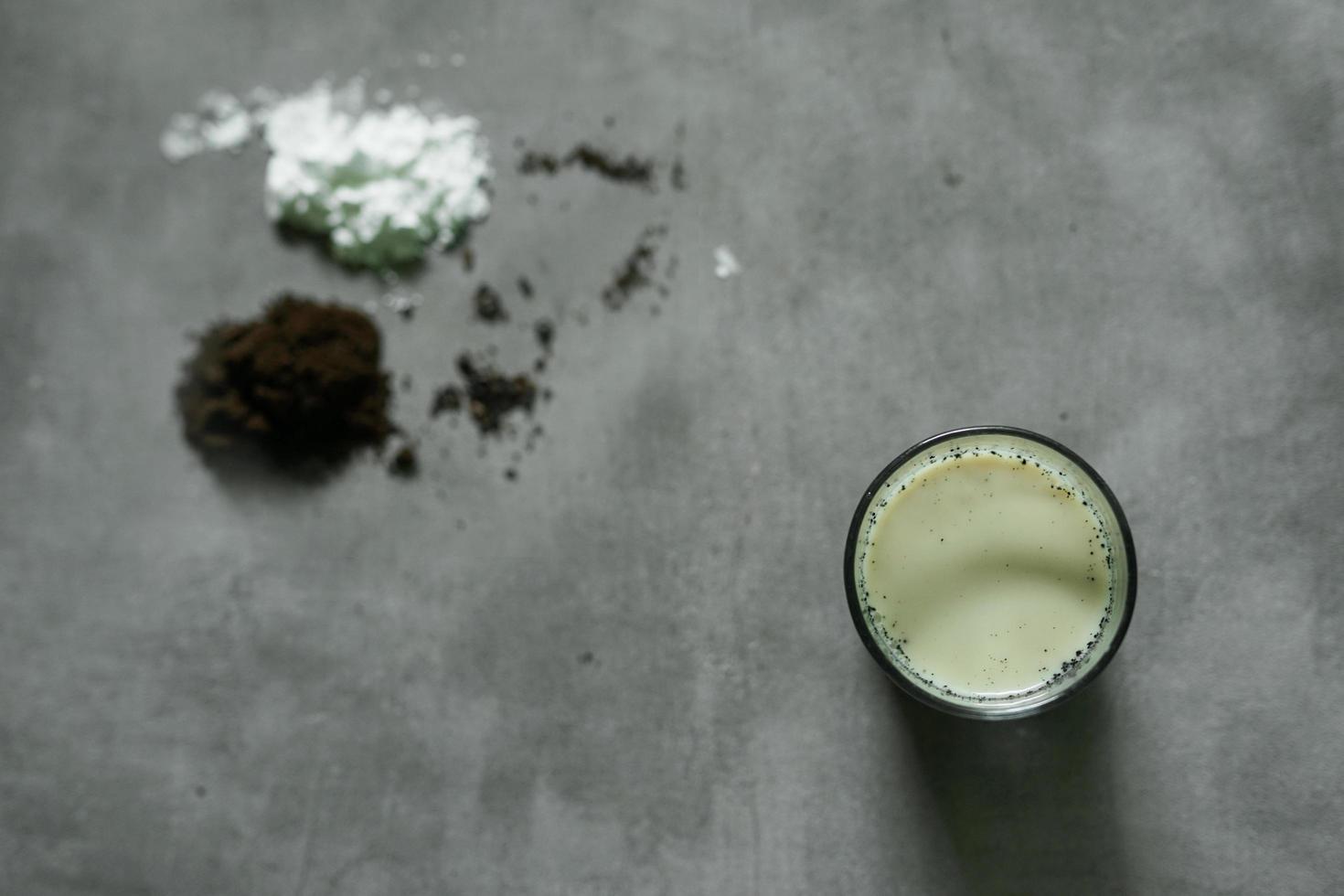 bebida de leche de café con ingredientes crudos sobre fondo de hormigón foto