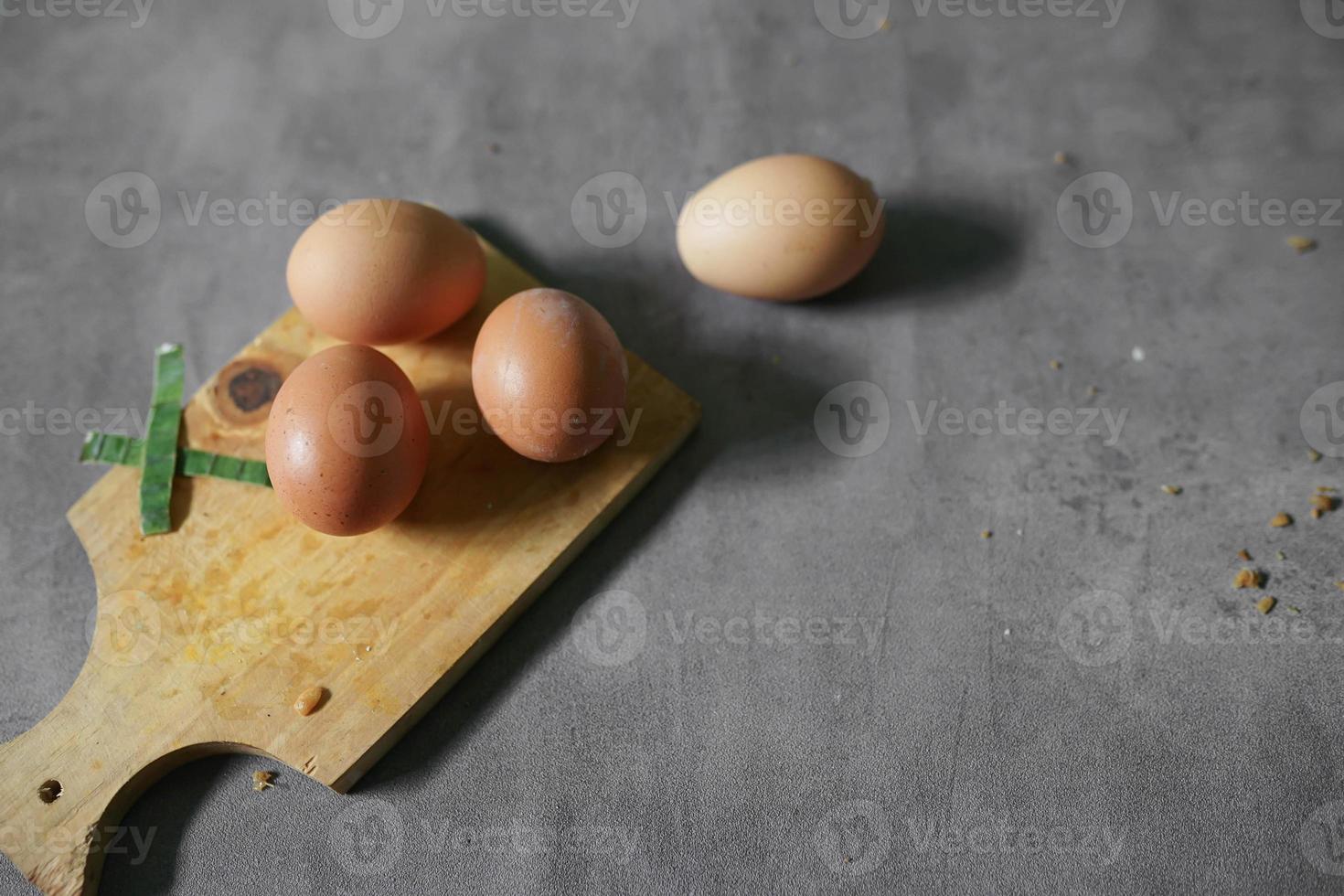 bunch of raw eggs on a cutting board with background concrete photo