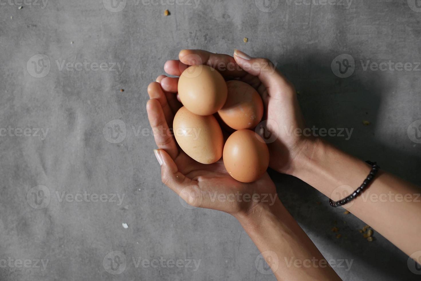 a bunch of eggs on a hand on a concrete background photo