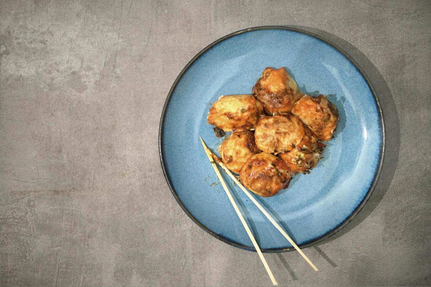 traditional japanese food, takoyaki with sauce on a blue plate photo