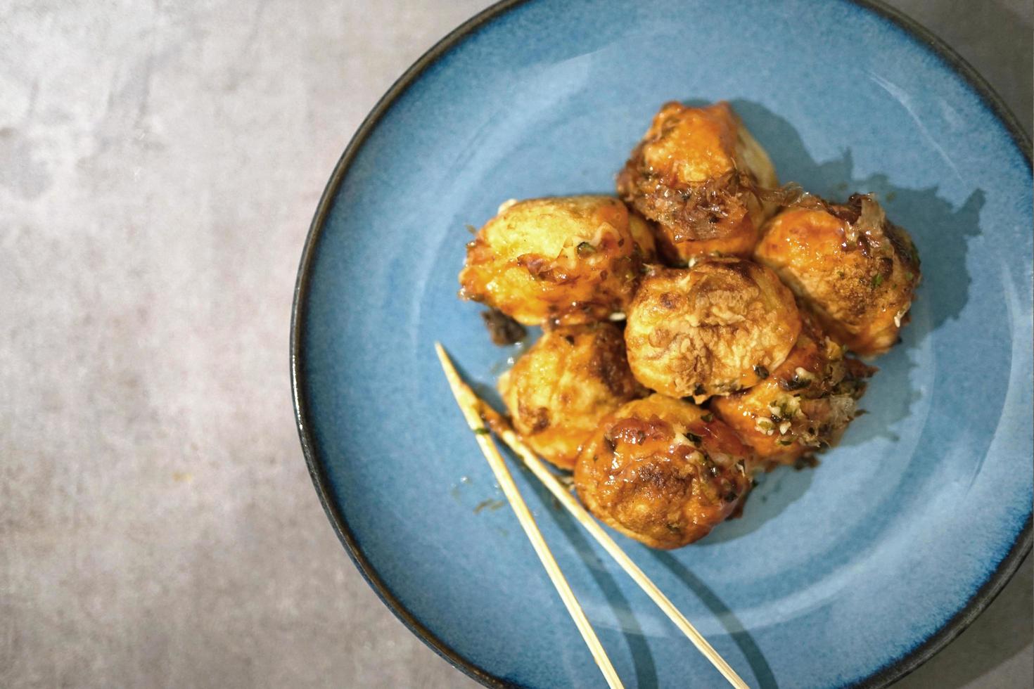 traditional japanese food, takoyaki with sauce on a blue plate photo