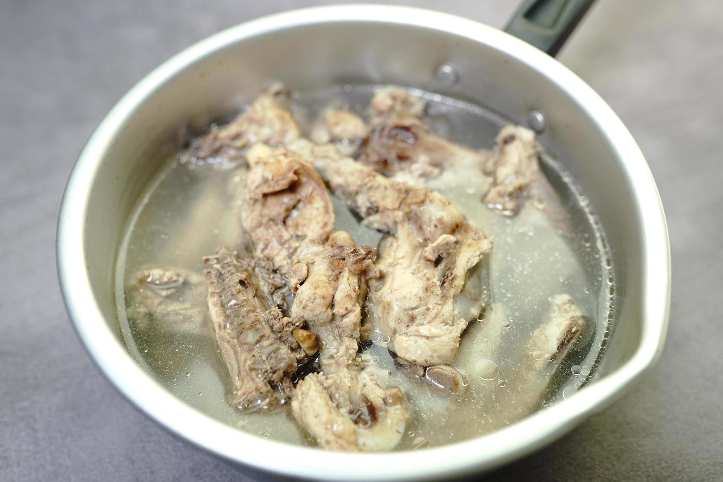 chicken stock soup in a pot on a concrete background photo