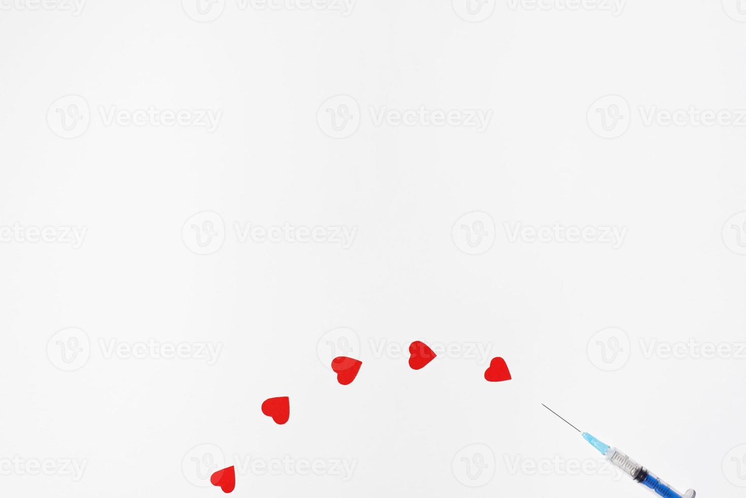 Safe vaccination concept. Syringe like injecting hearts on a white background, copy space. photo