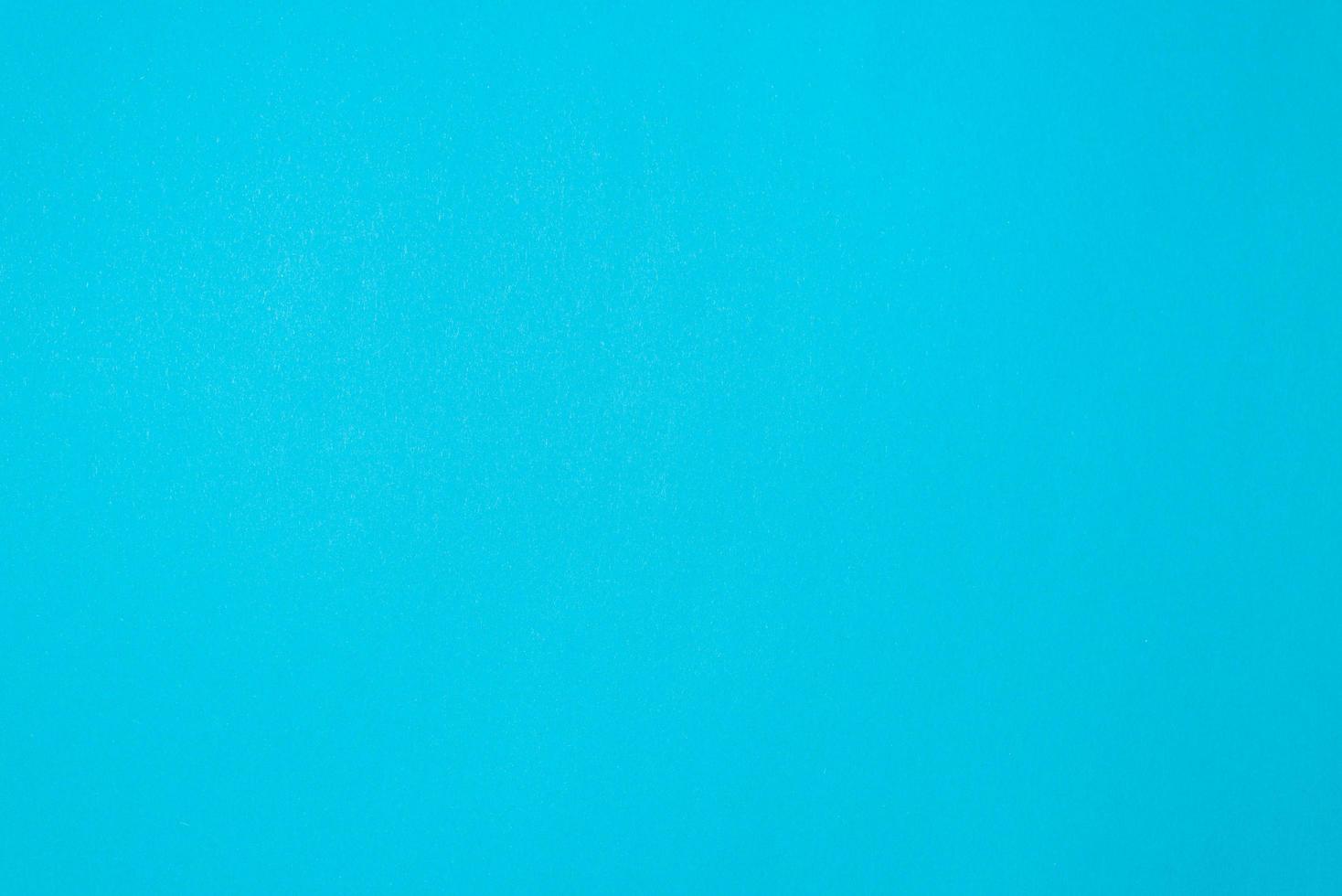 Blue textured paper background, top view. Simple one-color backdrop photo