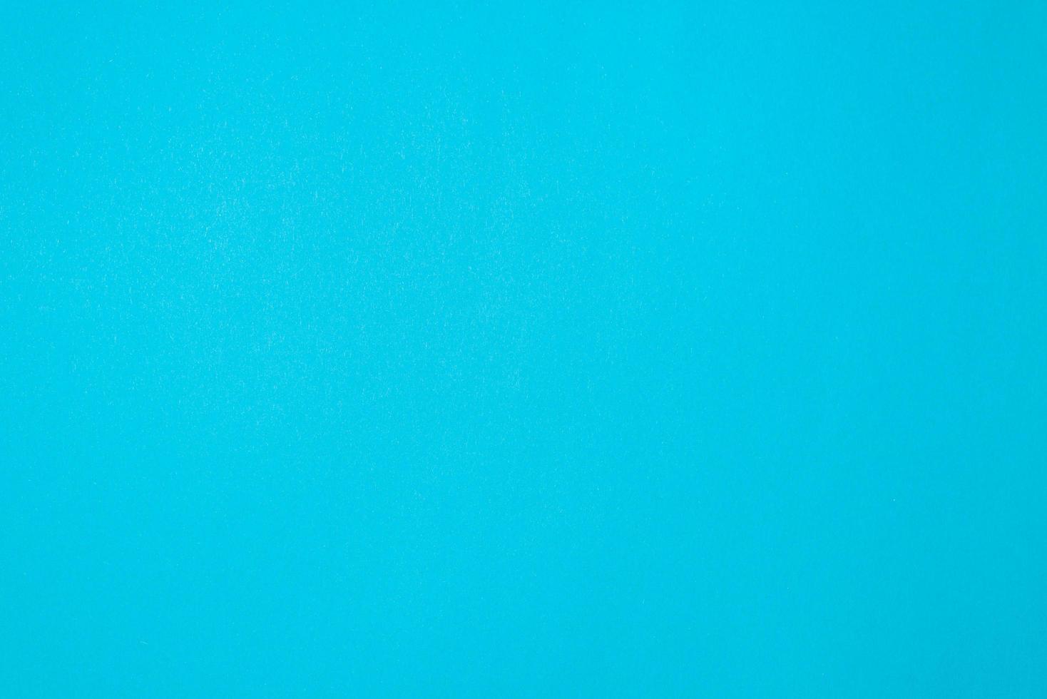 Blue textured paper background, top view. Simple one-color backdrop photo