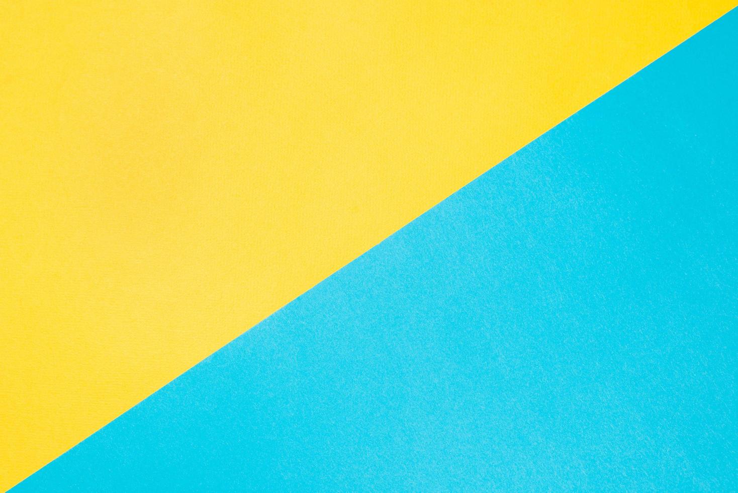 Textured paper background, top view. Yellow-blue colored backdrop. Two dioganal backgrounds photo