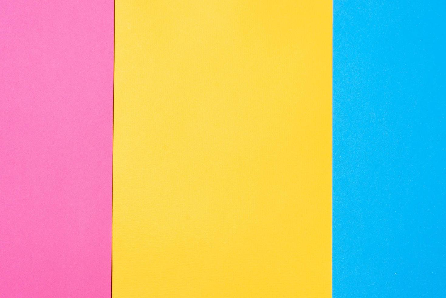 Three colored vertical layers, copy space. Multicolored paper background. Yellow pink and blue geometric backdrop. photo