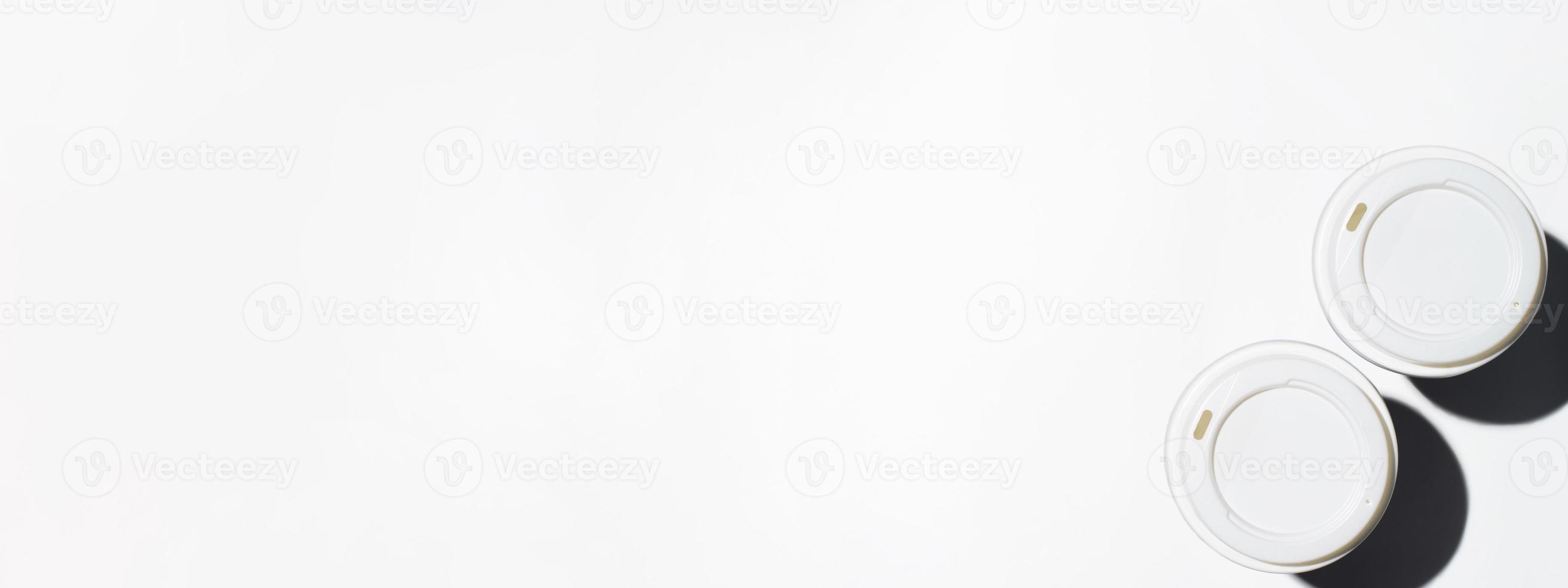 Two disposable cups of coffee on a white background, top view. Banner, copy space photo