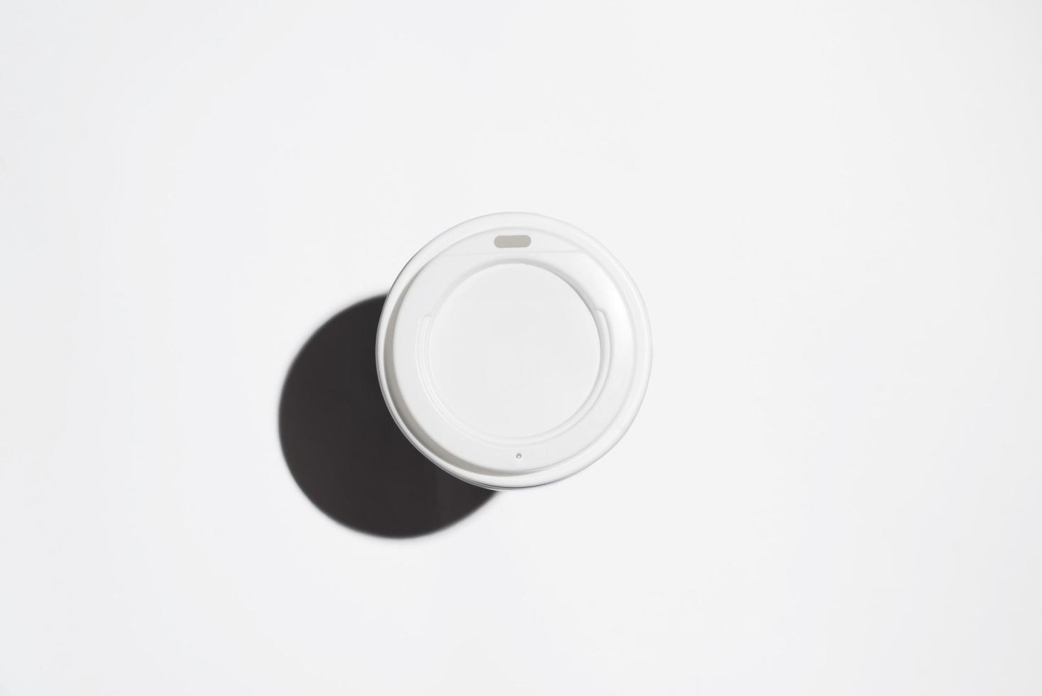 Disposable cup of coffee on a white background, top view. Minimalistic photo, selective focus photo