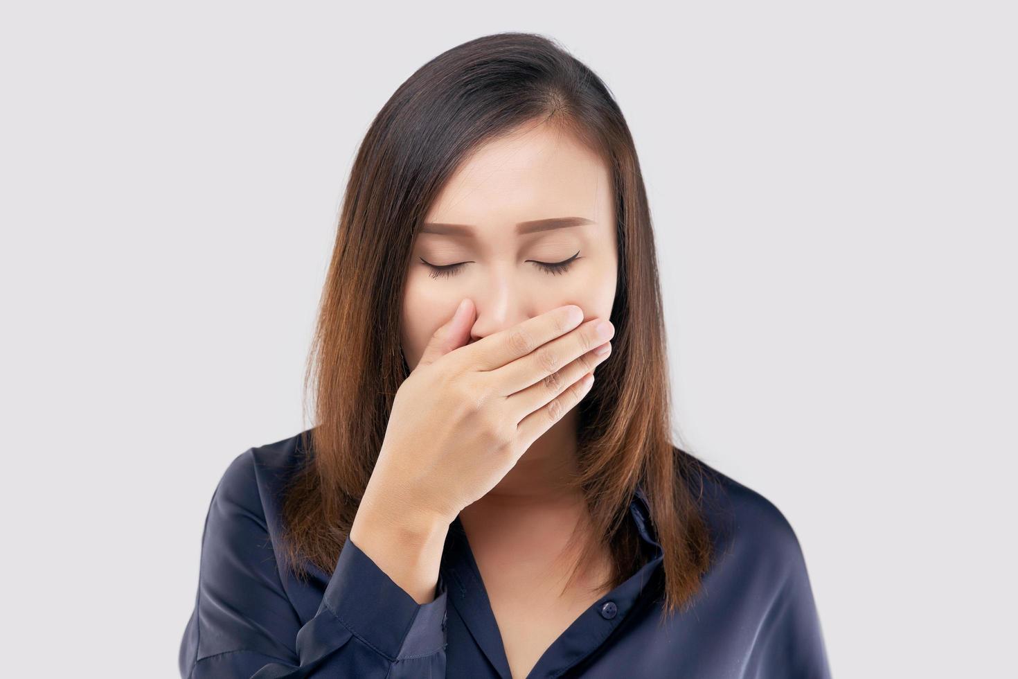 Portrait of tired girl who yawns. A woman yawning on a light gray background photo