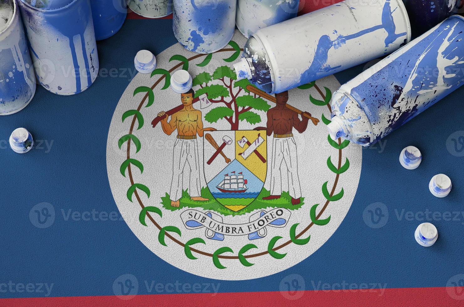 Belize flag and few used aerosol spray cans for graffiti painting. Street art culture concept photo