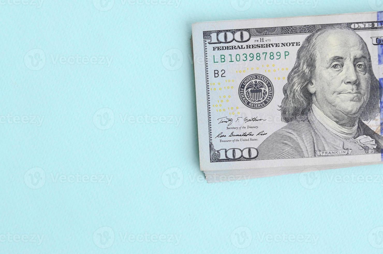 US dollar bills of a new design with a blue stripe in the middle is lies on a light blue background photo