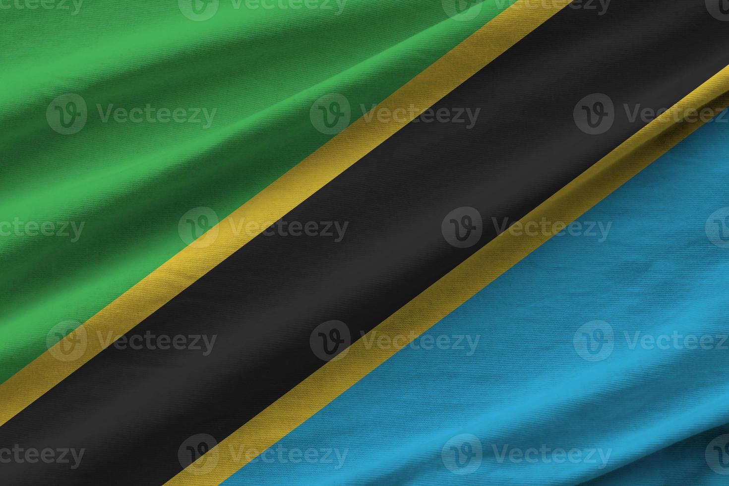 Tanzania flag with big folds waving close up under the studio light indoors. The official symbols and colors in banner photo