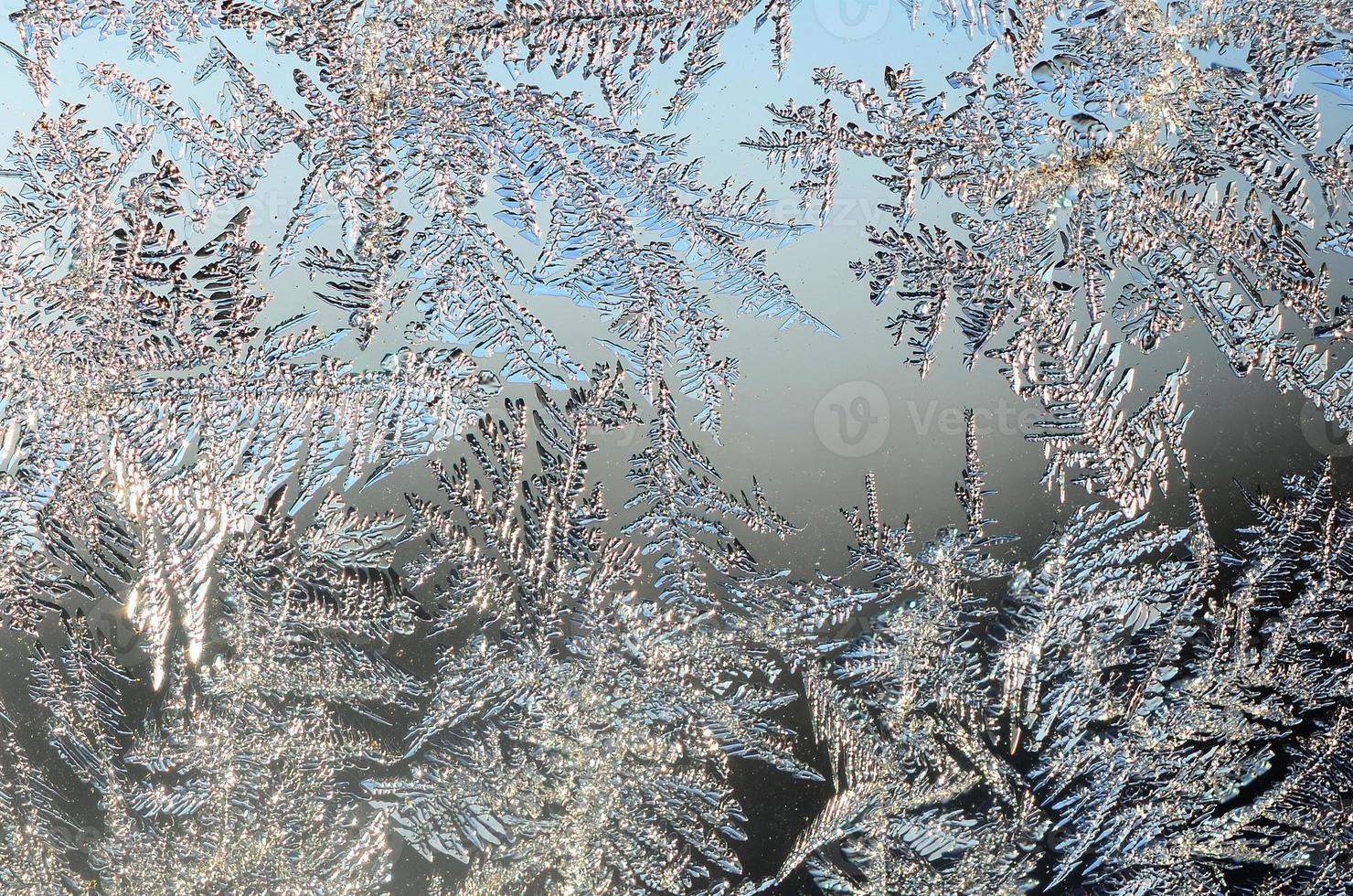 Snowflakes frost rime macro on window glass pane photo