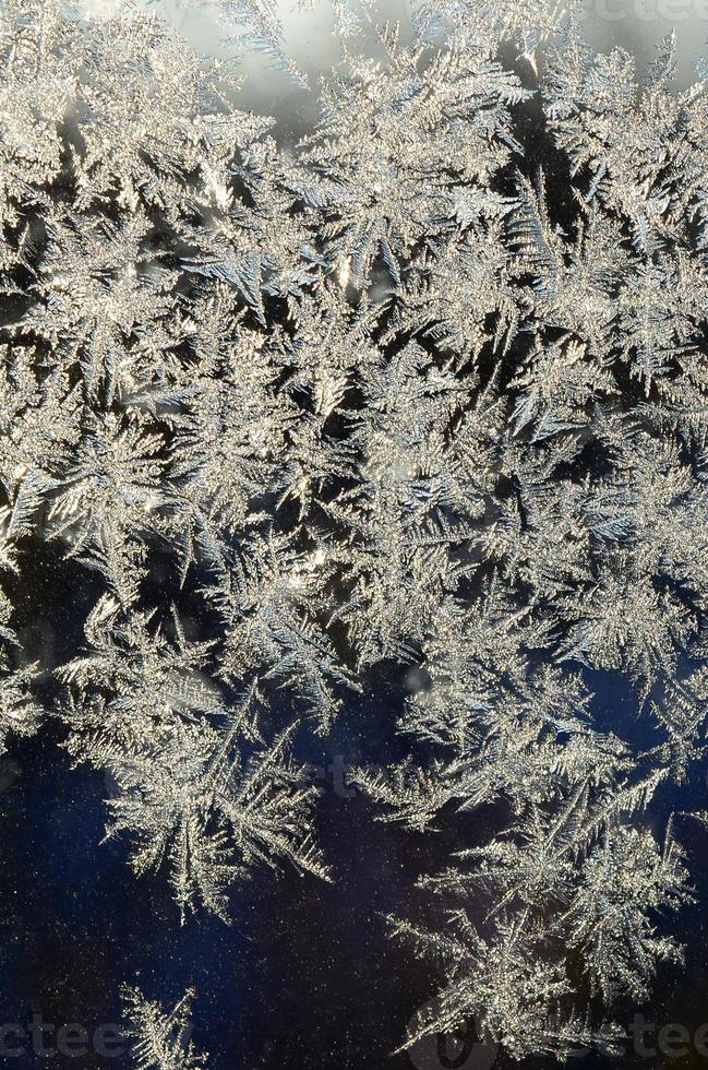 Snowflakes frost rime macro on window glass pane photo