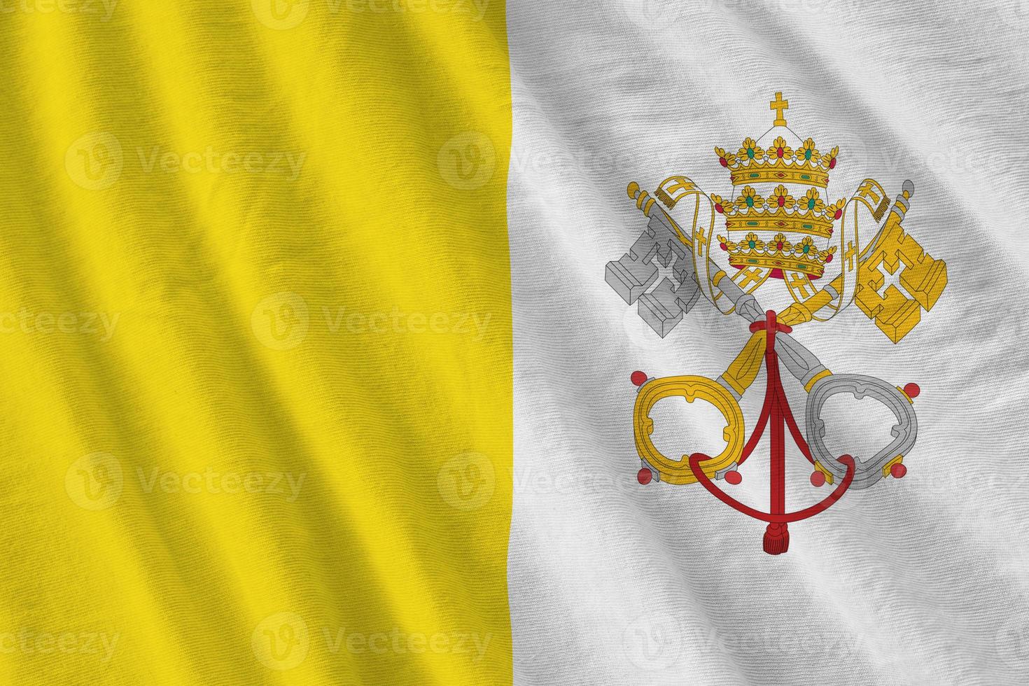 Vatican City State flag with big folds waving close up under the studio light indoors. The official symbols and colors in banner photo