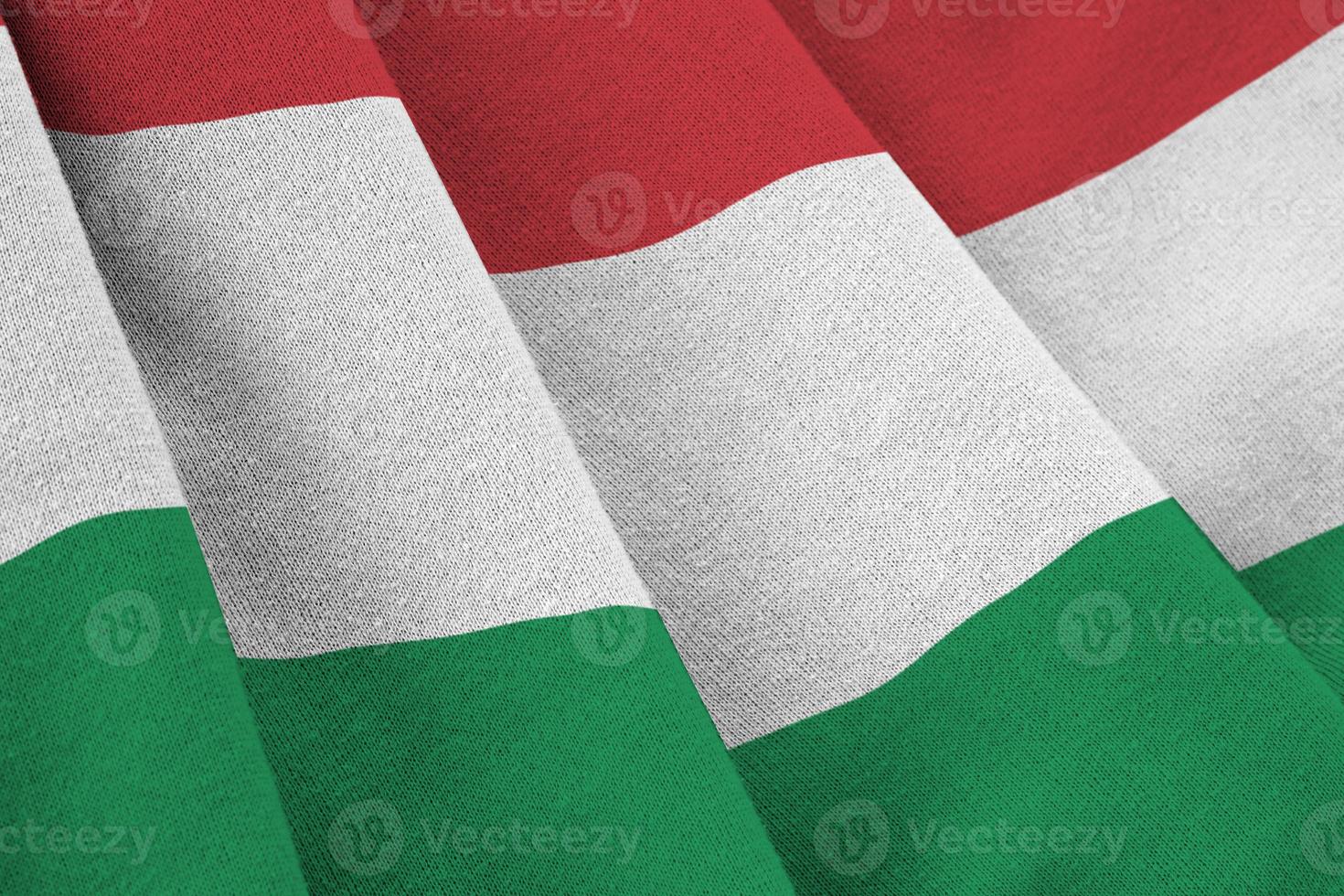 Hungary flag with big folds waving close up under the studio light indoors. The official symbols and colors in banner photo