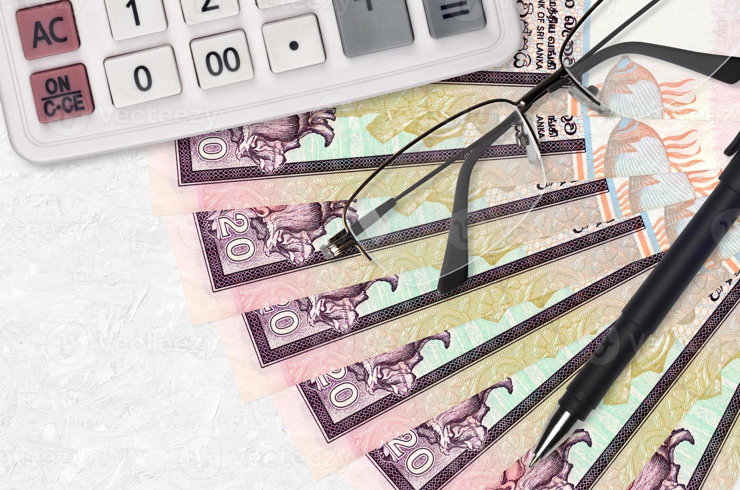 20 Sri Lankan rupees bills fan and calculator with glasses and pen. Business loan or tax payment season concept photo