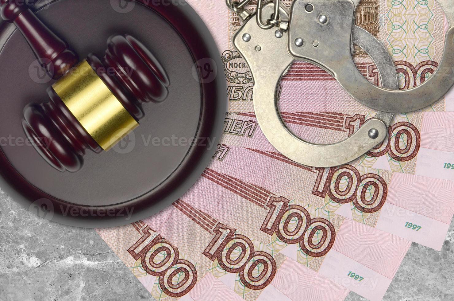 100 russian rubles bills and judge hammer with police handcuffs on court desk. Concept of judicial trial or bribery. Tax avoidance photo