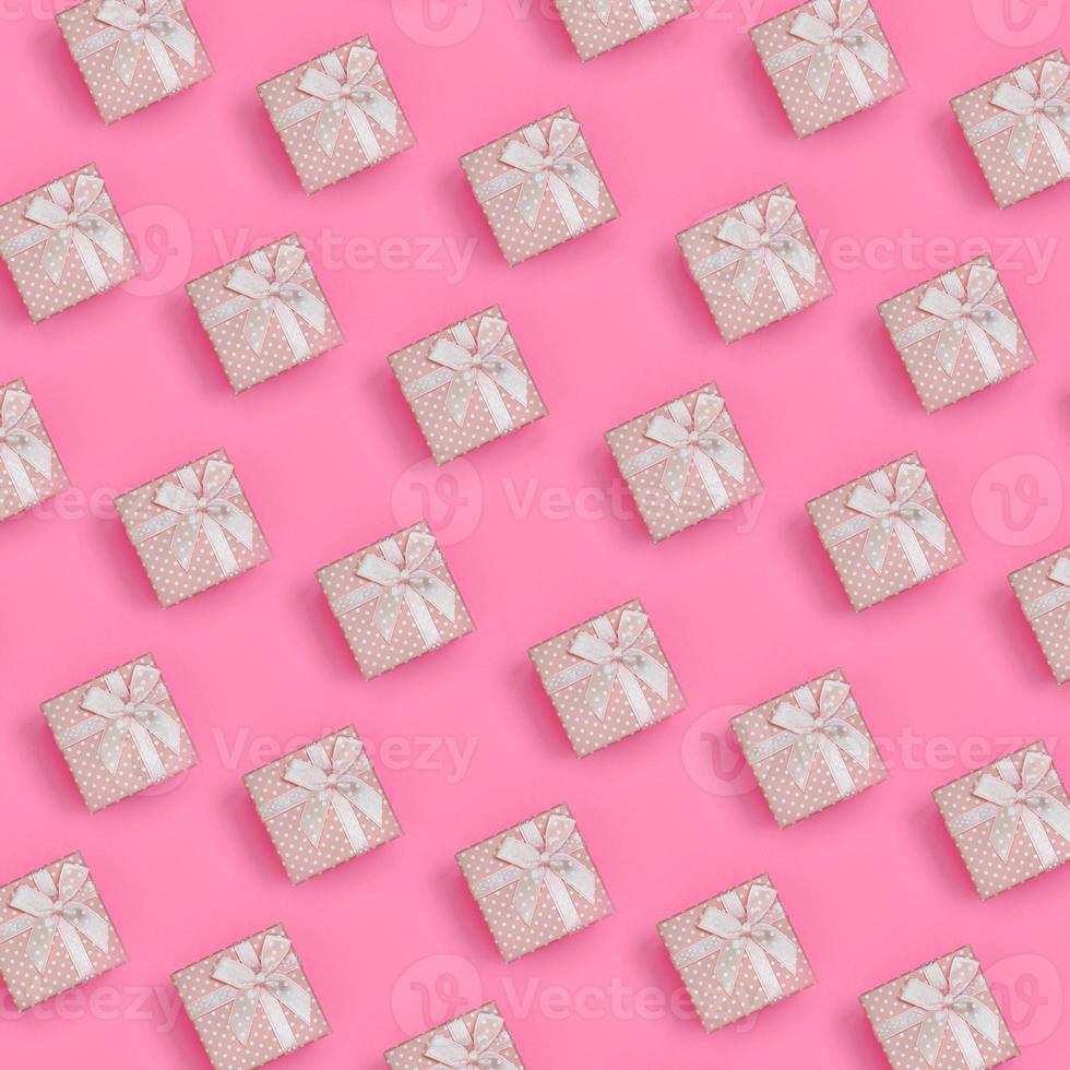 A lot of pink gift boxes lies on texture background of fashion pastel pink color paper in minimal concept. Abstract trendy pattern photo