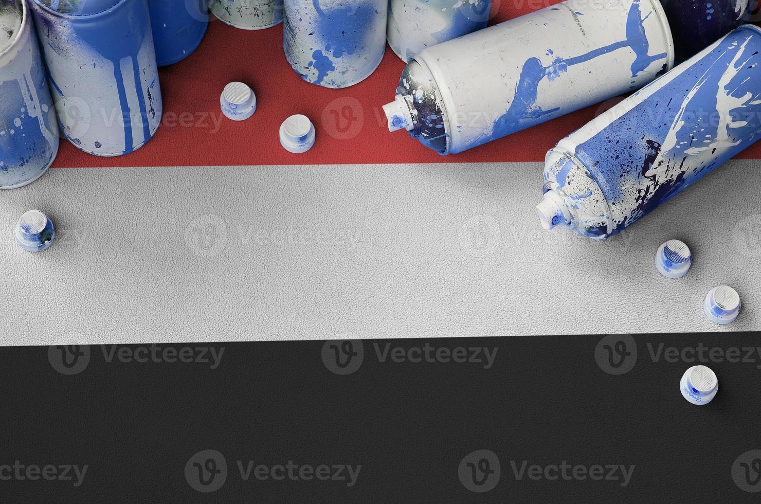bandera de yemen y pocas latas de aerosol usadas para pintar graffiti. concepto de cultura de arte callejero foto