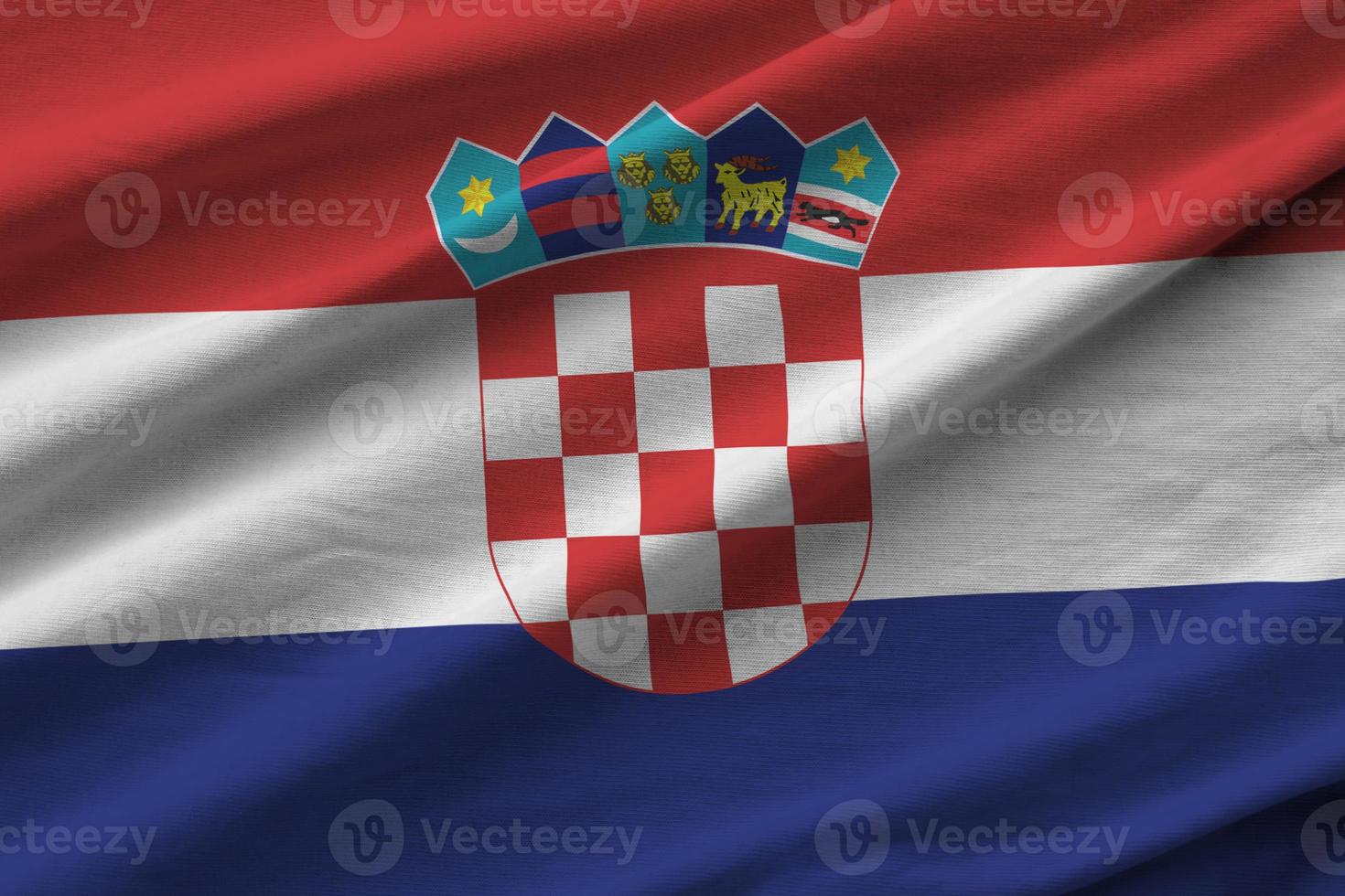 Croatia flag with big folds waving close up under the studio light indoors. The official symbols and colors in banner photo