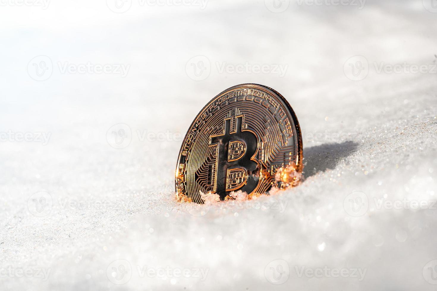 bitcoin se encuentra en la nieve y brilla al sol. foto