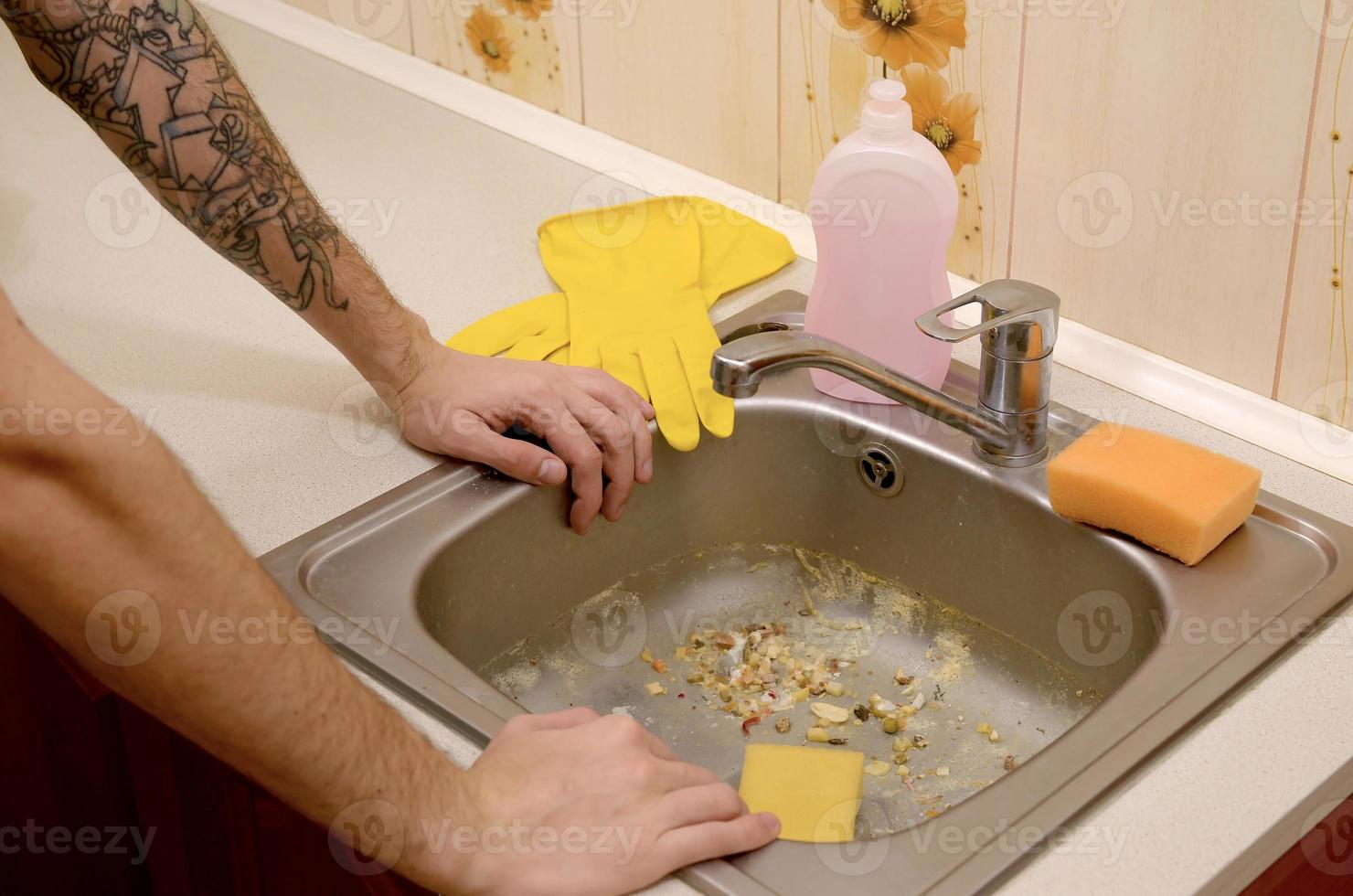 The housekeeper was faced with the problem of washing an overly dirty sink filled with food particles photo