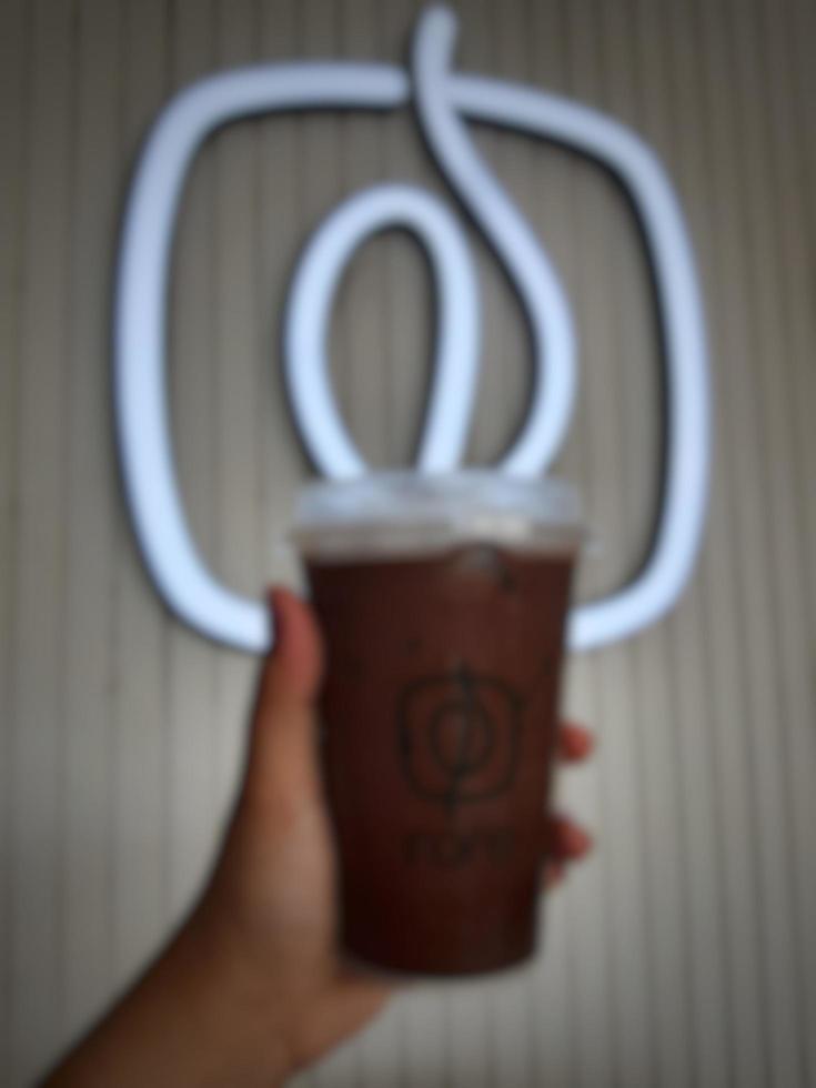 Jakarta, Indonesia in October 2022. A hand is holding an iced moccachino belonging to the Fore brand. photo