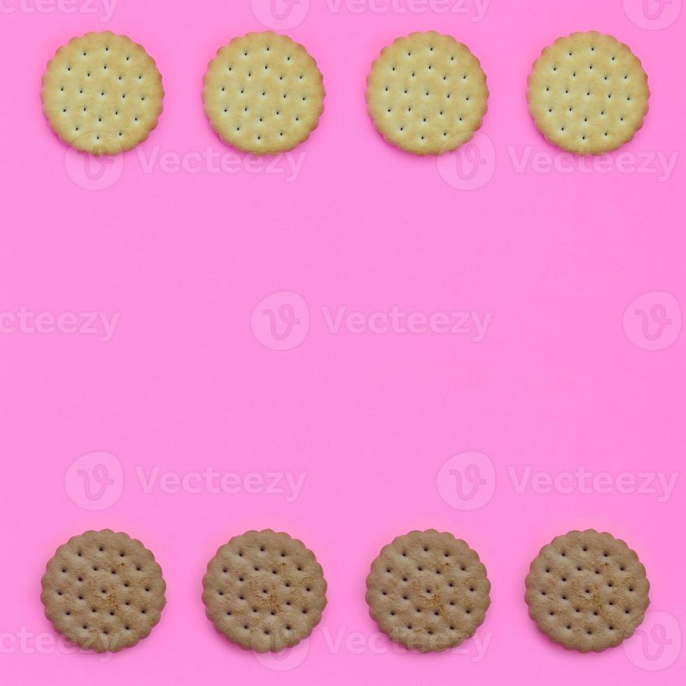 Pattern of a brown biscuits on a pink background. Trendy minimal concept of food and dessert. Abstract flat lay, top view photo