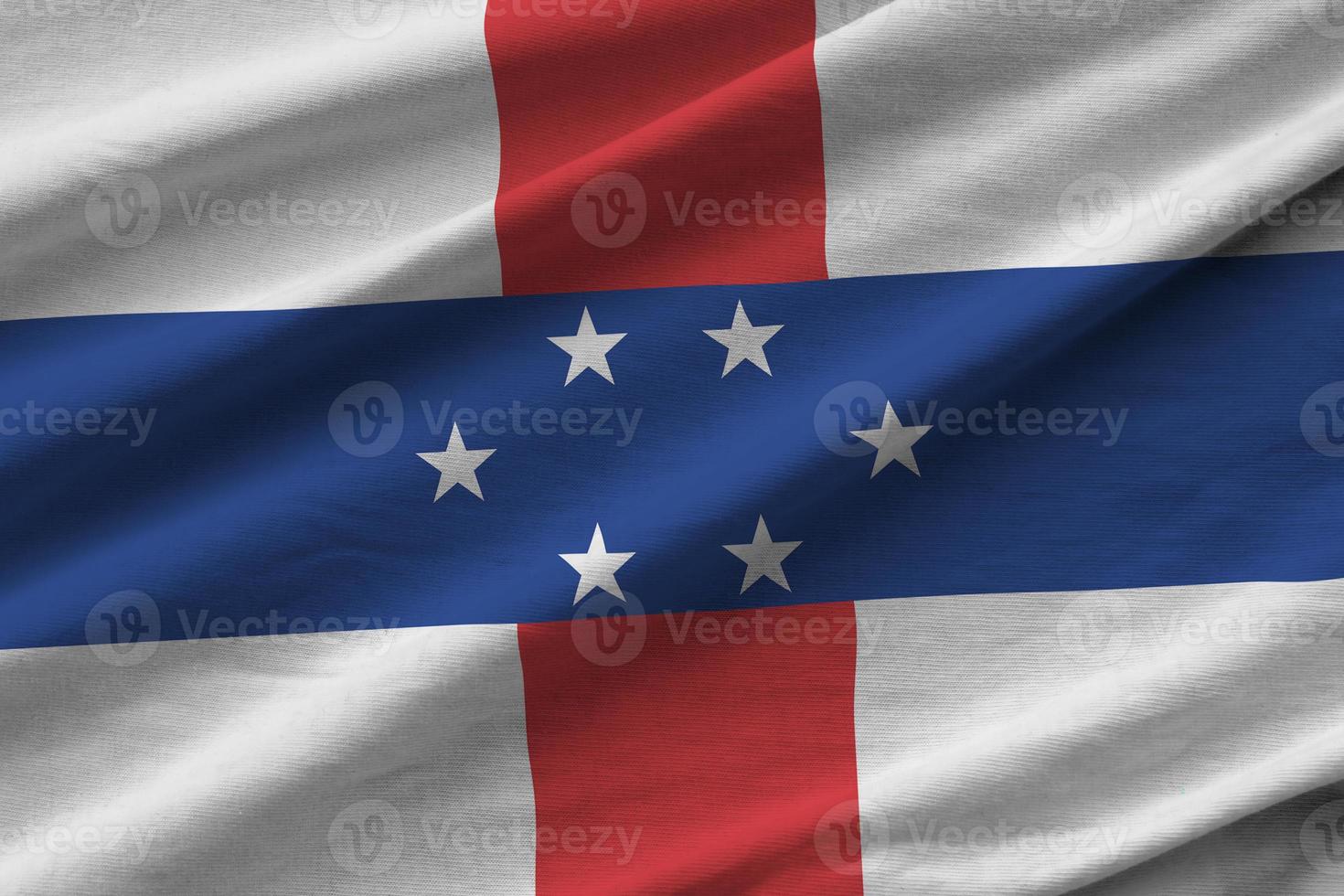 Netherlands Antilles flag with big folds waving close up under the studio light indoors. The official symbols and colors in banner photo