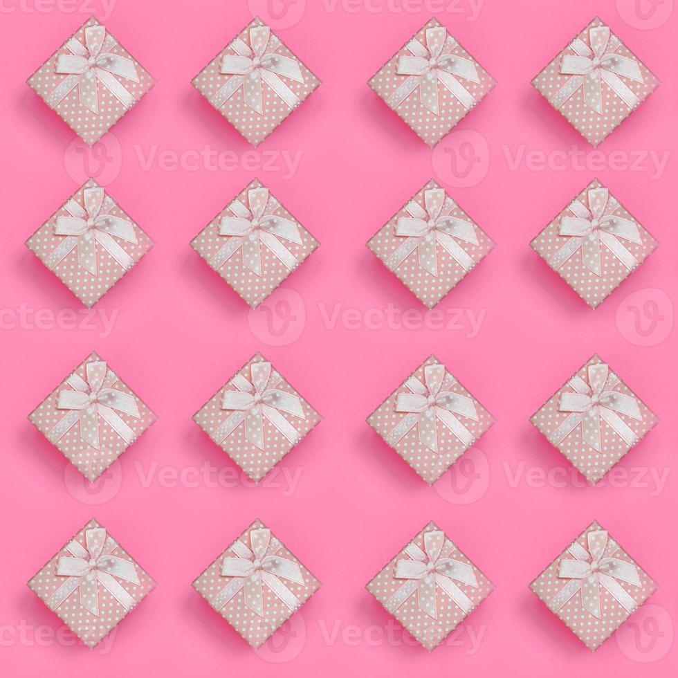 A lot of pink gift boxes lies on texture background of fashion pastel pink color paper in minimal concept. Abstract trendy pattern photo