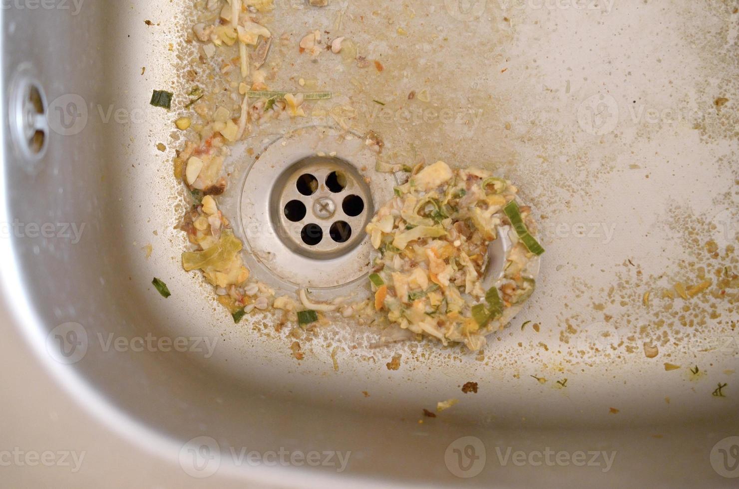 cerrar el desagüe sucio del fregadero de la cocina con partículas de comida foto