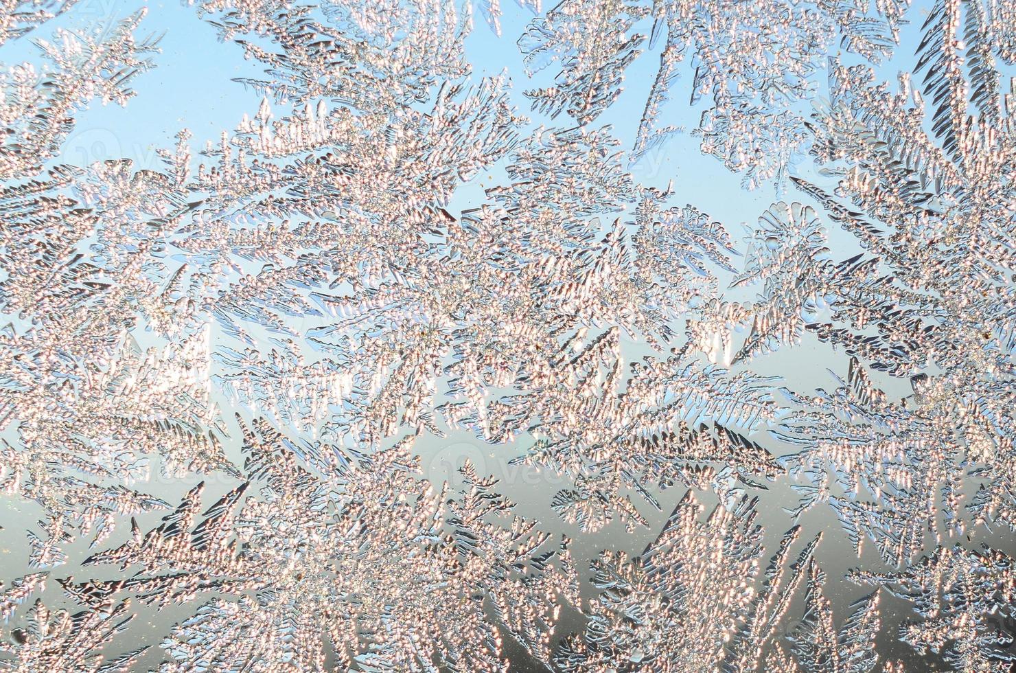 Snowflakes frost rime macro on window glass pane photo