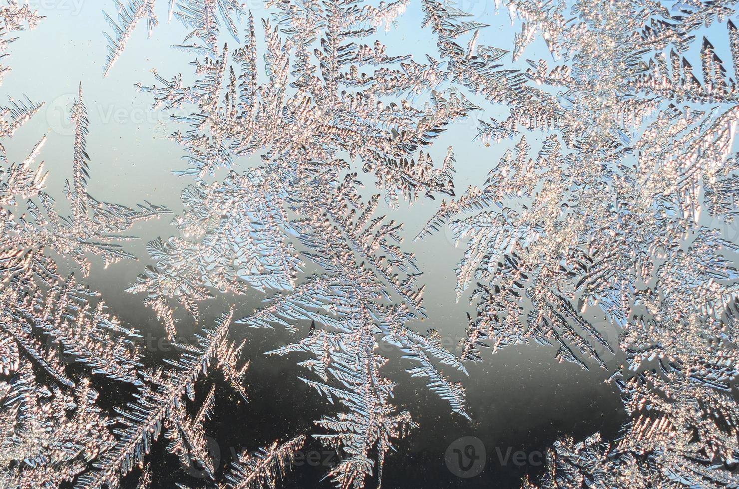 Snowflakes frost rime macro on window glass pane photo