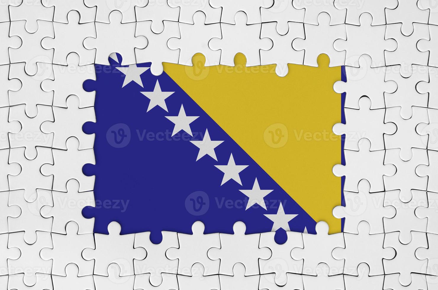 Bosnia and Herzegovina flag in frame of white puzzle pieces with missing central part photo