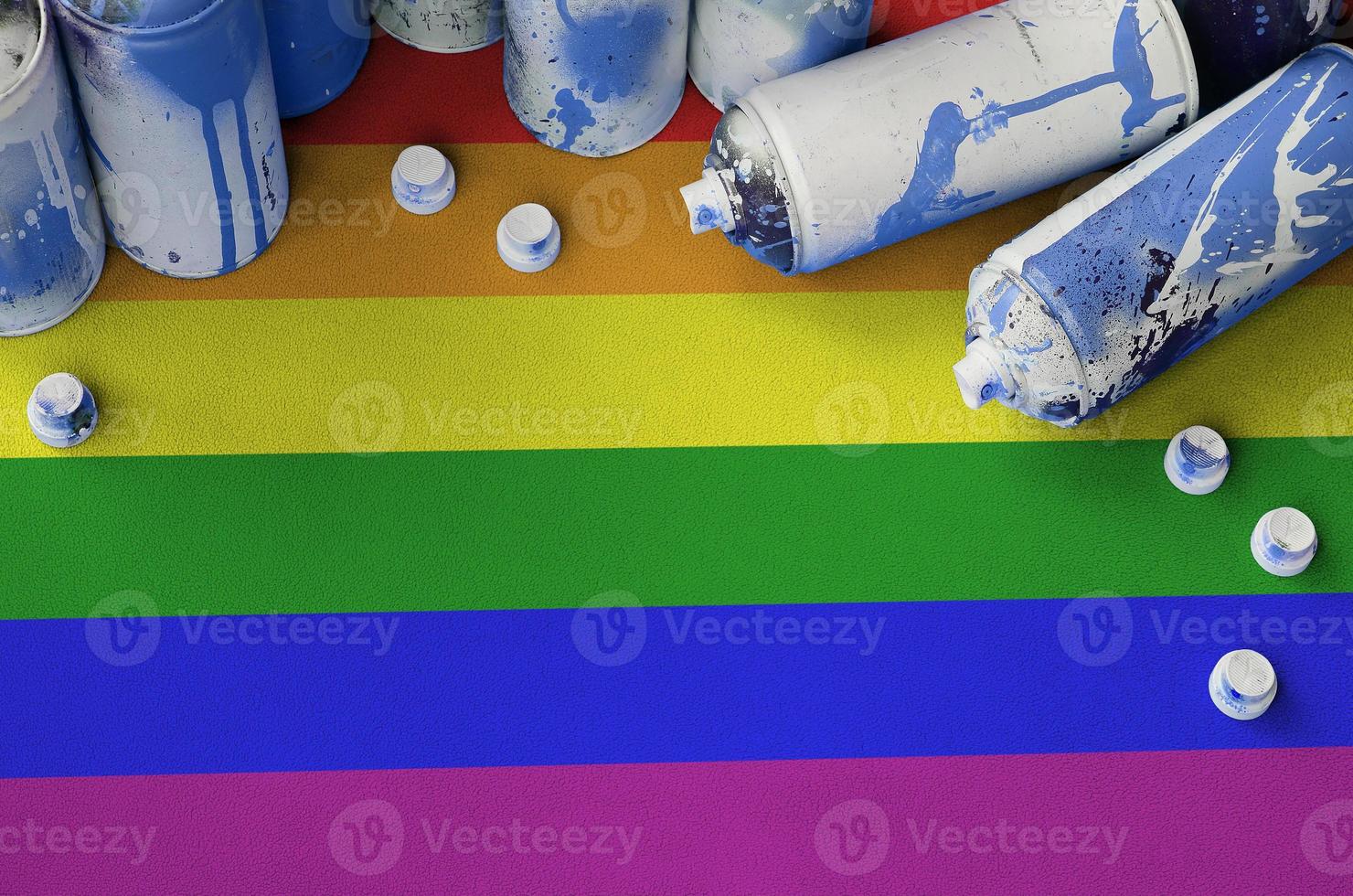 LGBT community flag and few used aerosol spray cans for graffiti painting. Street art culture concept photo