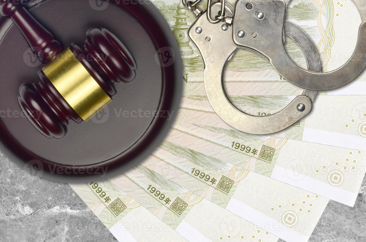 1 Chinese yuan bills and judge hammer with police handcuffs on court desk. Concept of judicial trial or bribery. Tax avoidance photo