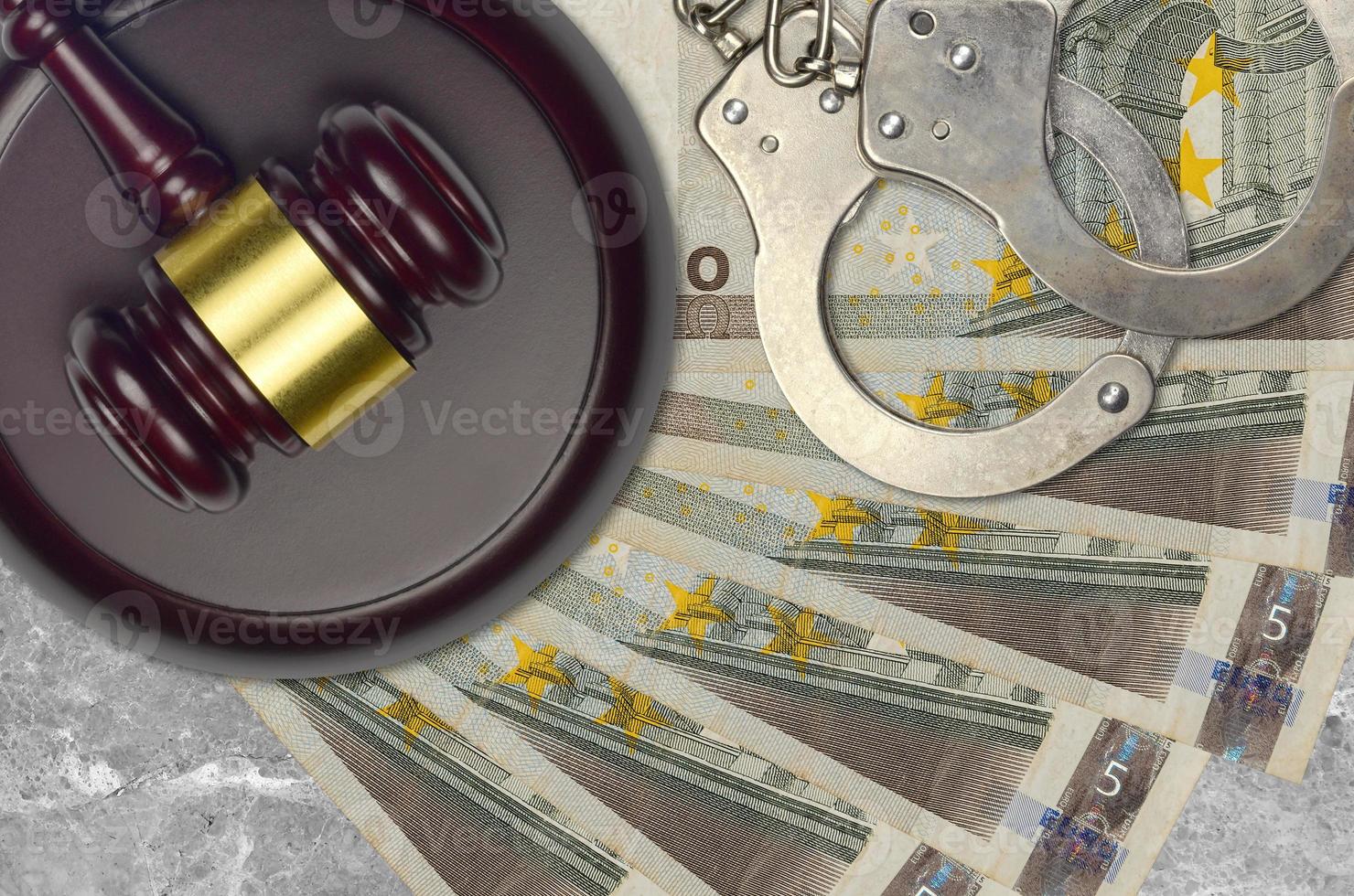 5 euro bills and judge hammer with police handcuffs on court desk. Concept of judicial trial or bribery. Tax avoidance photo