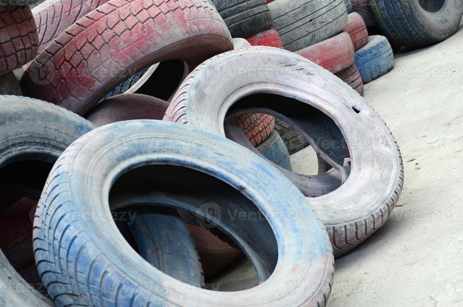 A picture of many old used tires left on a waste dump photo