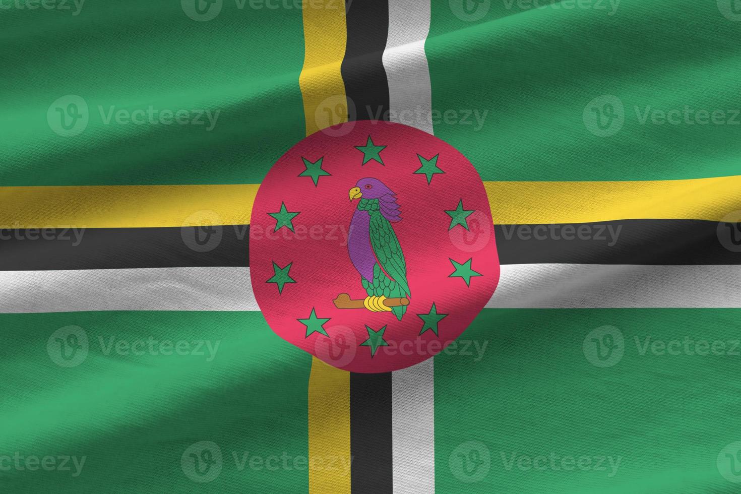 Dominica flag with big folds waving close up under the studio light indoors. The official symbols and colors in banner photo