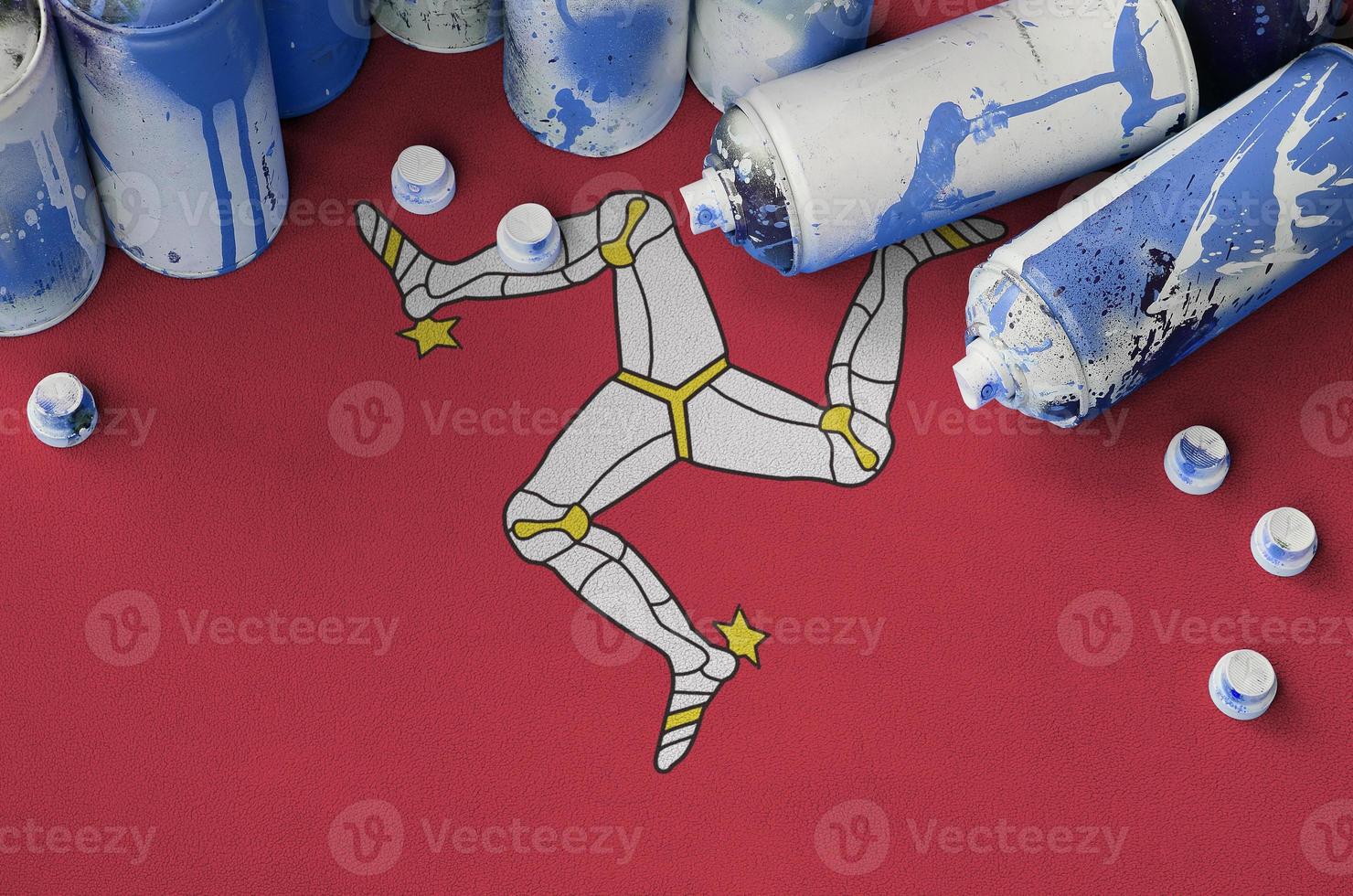 Isle of Man flag and few used aerosol spray cans for graffiti painting. Street art culture concept photo