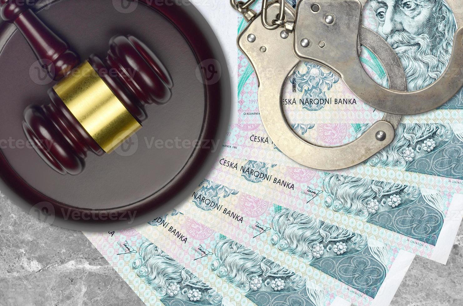 100 Czech korun bills and judge hammer with police handcuffs on court desk. Concept of judicial trial or bribery. Tax avoidance photo