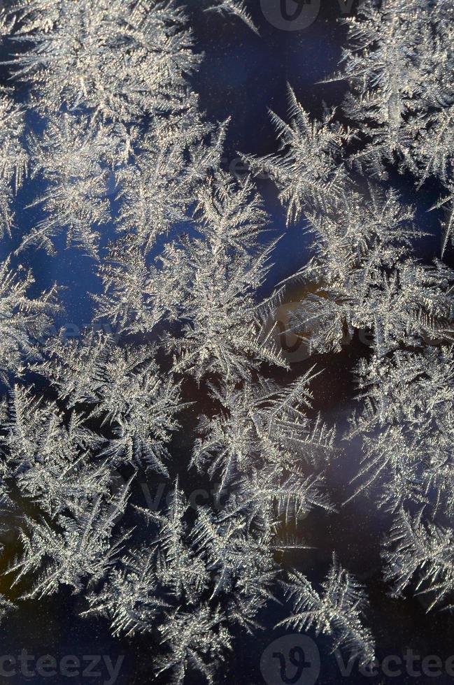 Snowflakes frost rime macro on window glass pane photo