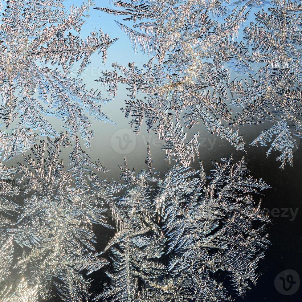 copos de nieve escarcha escarcha macro en el cristal de la ventana foto