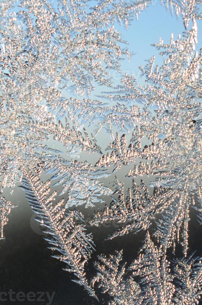 Snowflakes frost rime macro on window glass pane photo