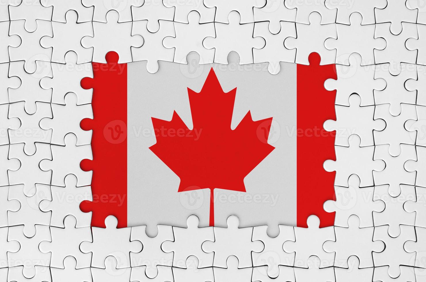 Canada flag in frame of white puzzle pieces with missing central part photo